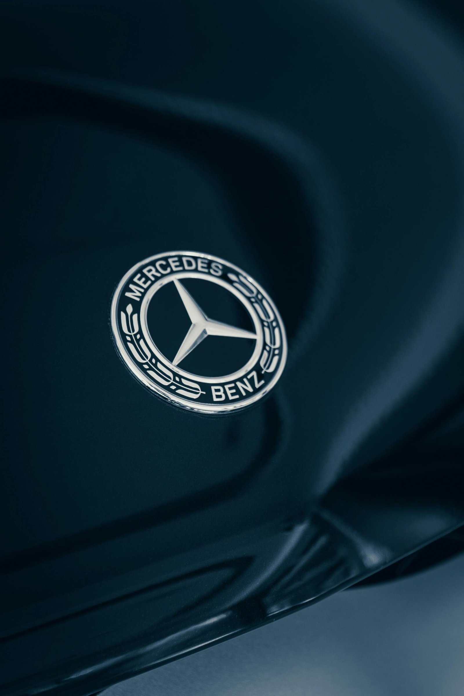 Detailed close-up of a Mercedes-Benz emblem with elegant reflections.